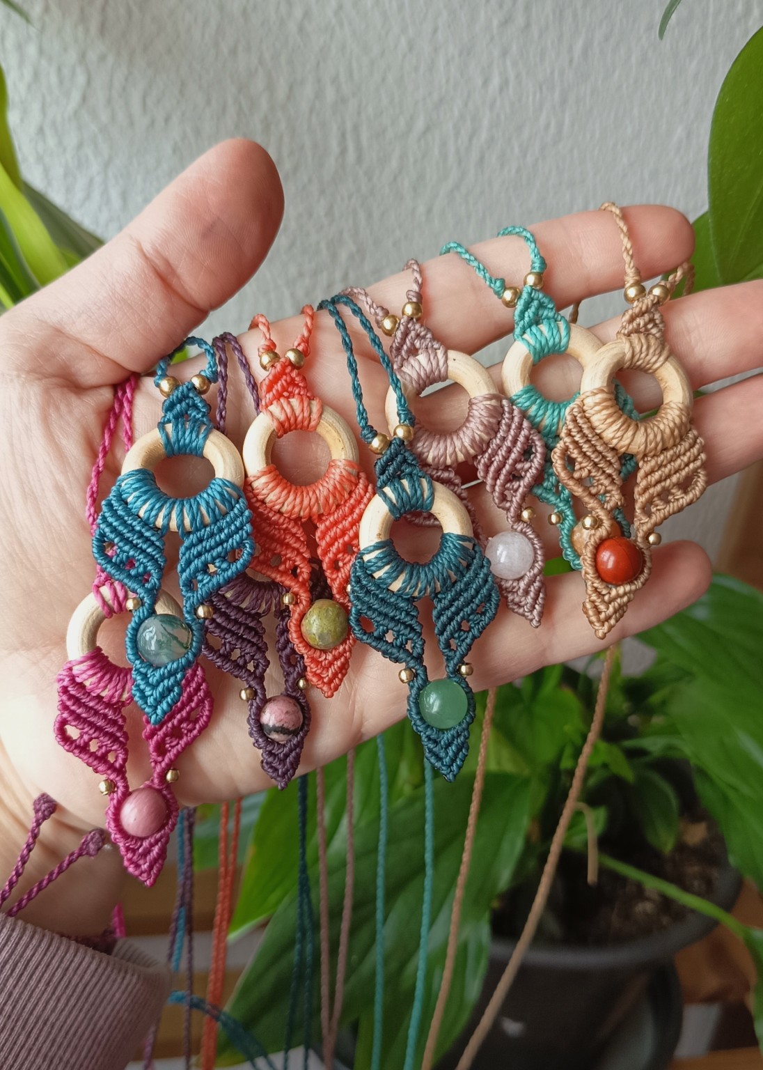 Mão com várias peças pequenas coloridas, argolas de madeira e cristais